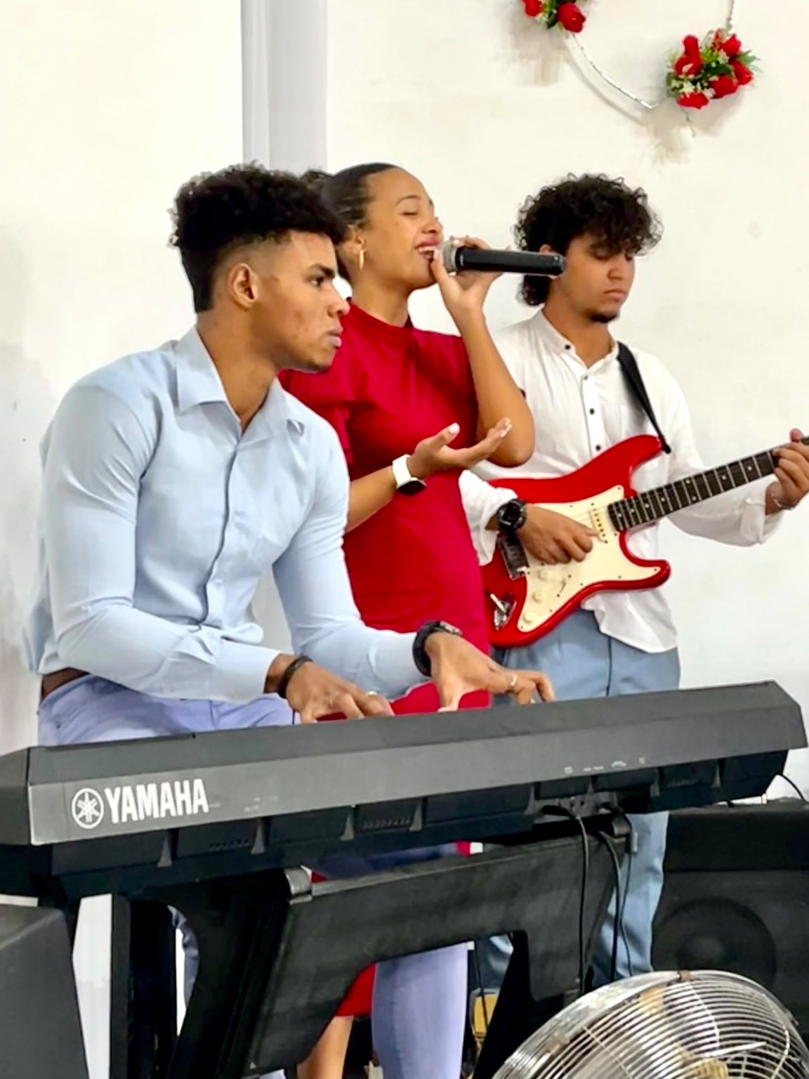 Daniel Montalvo al teclado junto a una cantante y un guitarrista durante una actividad musical